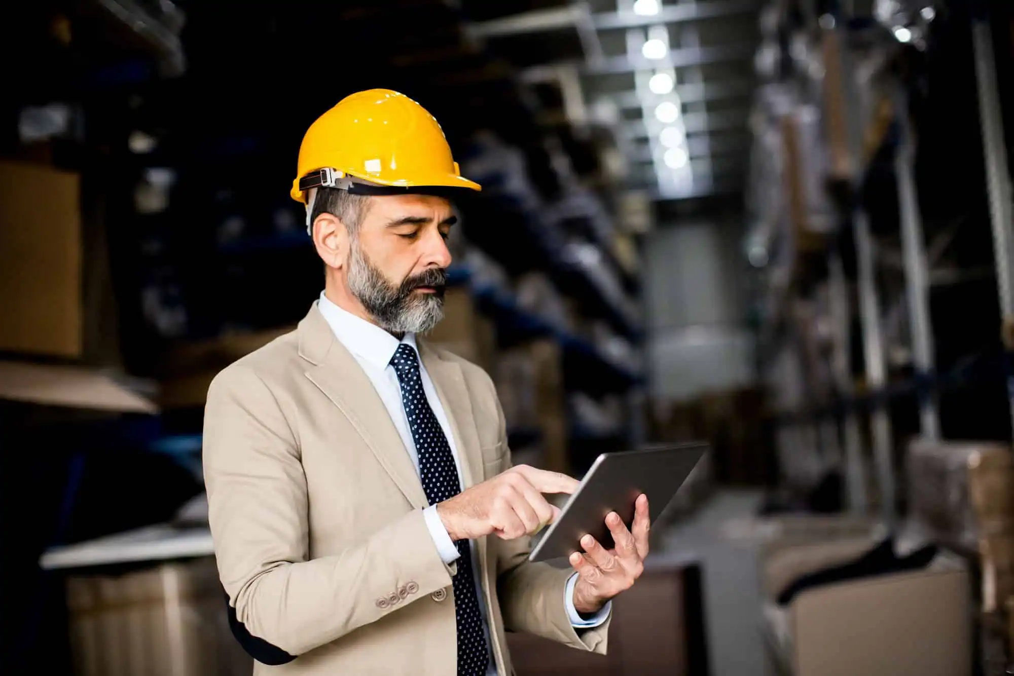 Middle-aged businessman with digital tablet in factory